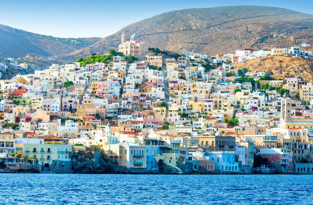Greek island with colorful houses and yachts.